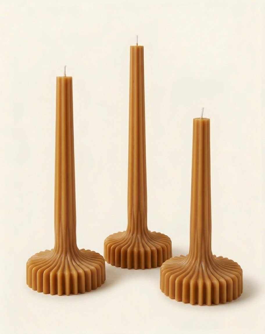 Caramel-colored Bloom Elegance candles with tall ribbed stems and fluted round bases.