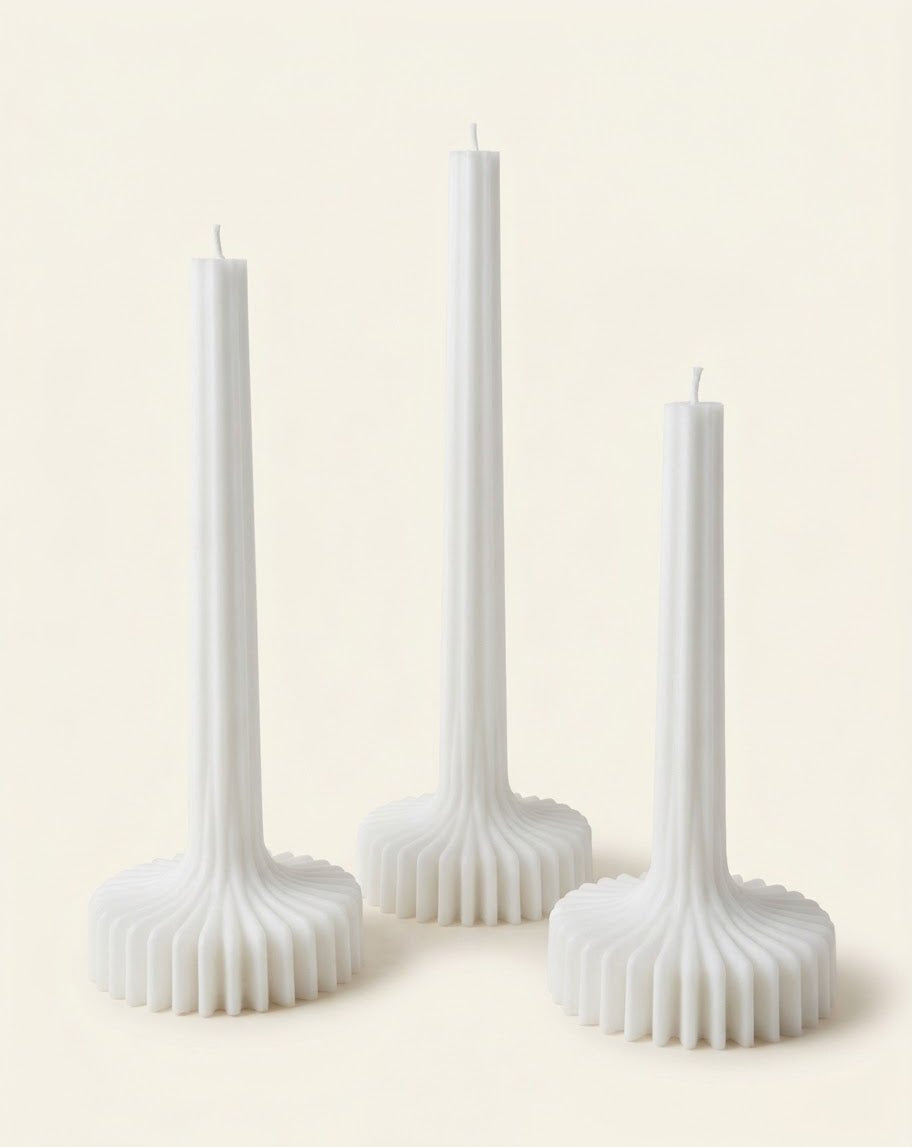 White Bloom Elegance candles with tall ribbed stems and fluted round bases.