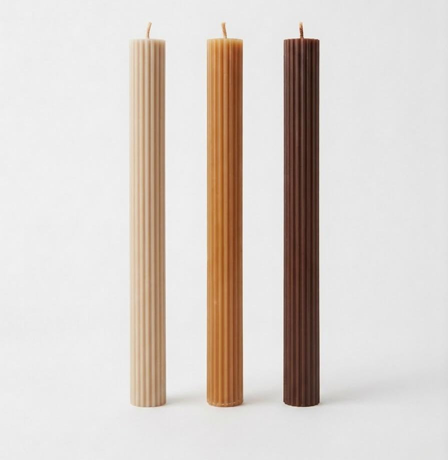 Beige, caramel-colored and brown Linear Elegance candles with straight sides and vertical ribs.
