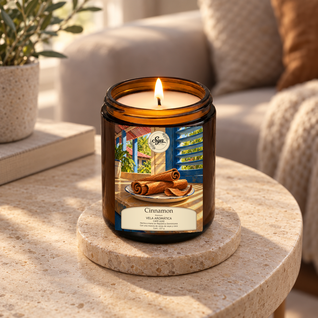 Vela Sya Cinnamon encendida en frasco ámbar con etiqueta Cinnamon ilustrada, sobre un posavasos de piedra en ambiente cálido.