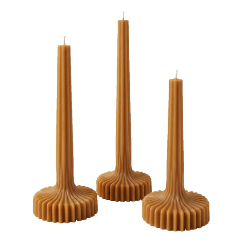 Caramel-colored Bloom Elegance candles with tall ribbed stems and fluted round bases on a white background.