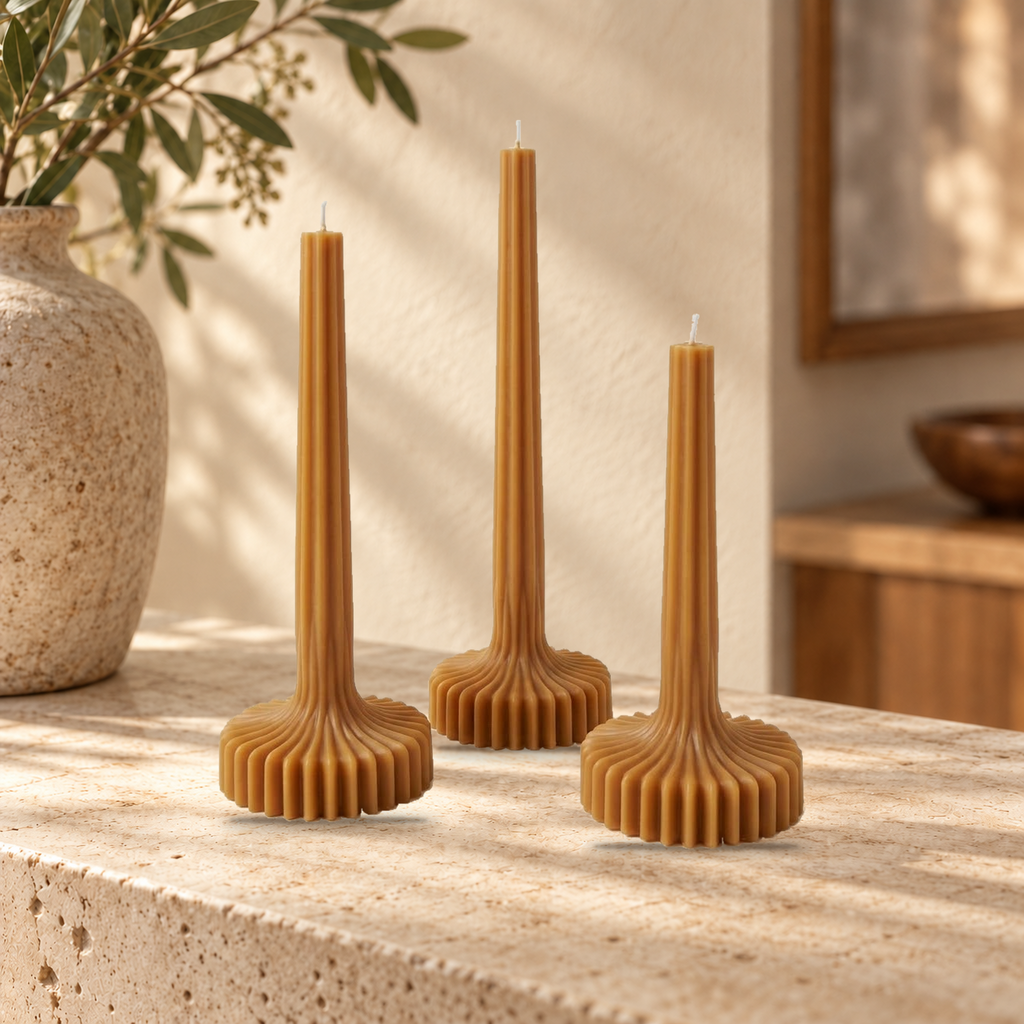 Trío Bloom Elegance de Sya color Caramel, apagado sobre una consola de piedra en una escena de hogar.