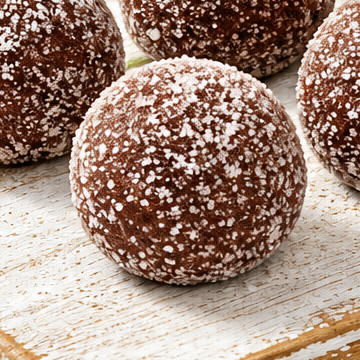 Close-up of a round, brown Bolitas de Tamarindo wax melt with a white-speckled surface.