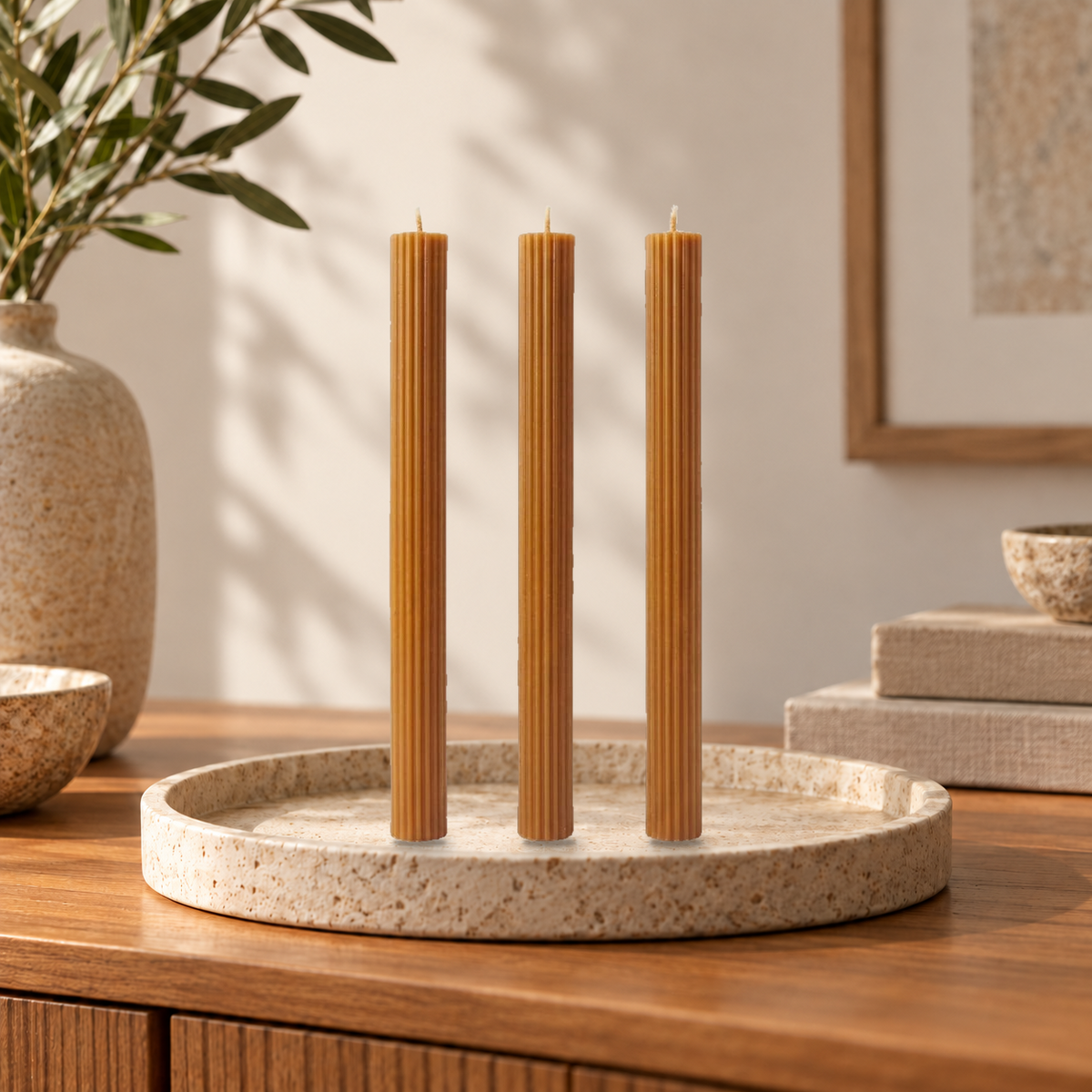 Trío Linear Elegance de Sya color Caramel, apagado y colocado sobre una bandeja de piedra en una escena de hogar.