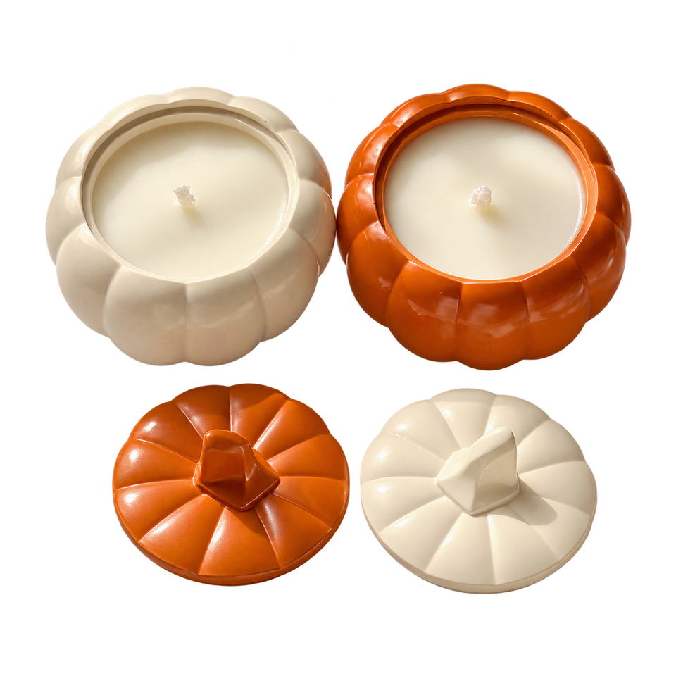 Velas Pumpkin Charm color crema y naranja en frascos con forma de calabaza, con tapas del mismo color colocadas al lado.