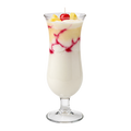 Piña Colada candle in a tall stemmed glass, with cream-colored and yellow layers, red accents and a visible wick.