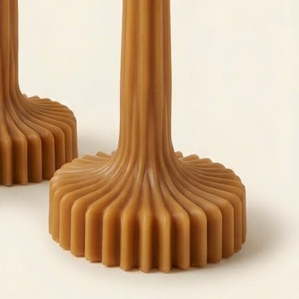 Close-up of the caramel-colored fluted base of a Bloom Elegance candle.
